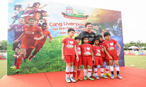 Ông Robbie Fowler, cựu ngôi sao lừng danh của Liverpool FC, chụp ảnh cùng thiếu nhi Việt Nam.