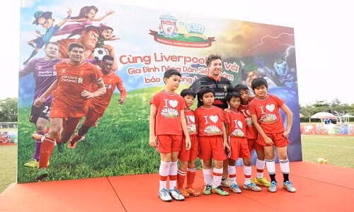 Ông Robbie Fowler, cựu ngôi sao lừng danh của Liverpool FC, chụp ảnh cùng thiếu nhi Việt Nam.
