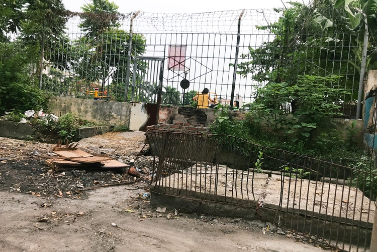 Khu đất được ngăn cách với bên ngoài bằng hàng rào sắt dựng cao.