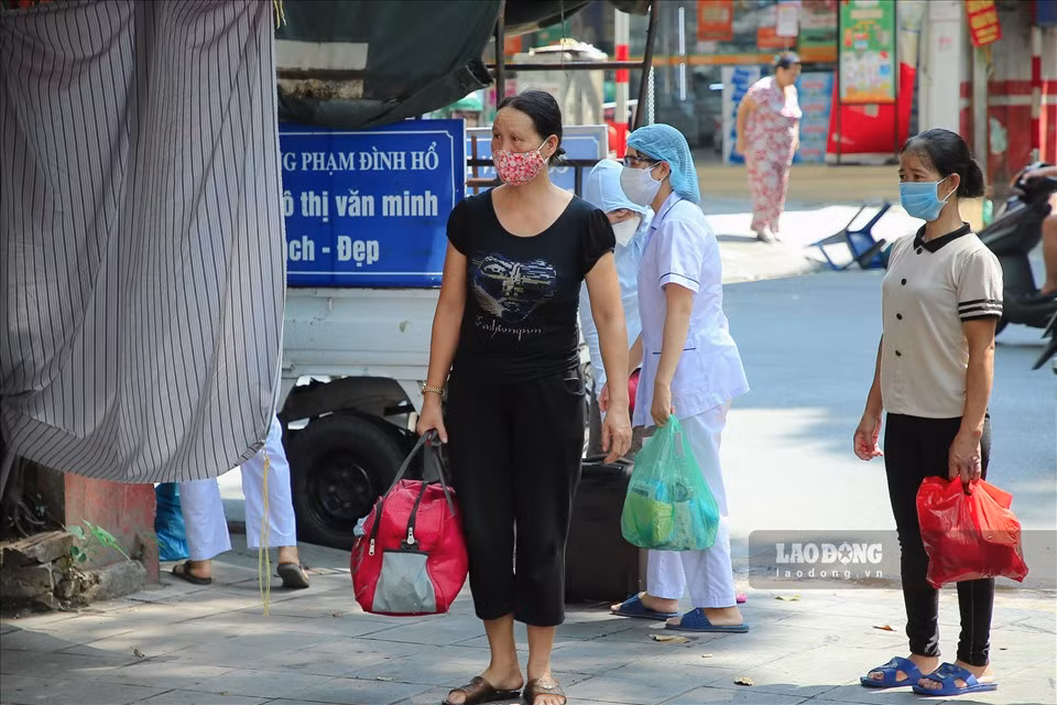 Bà Nguyễn Thị Thoa (áo đen, Phạm Đình Hổ, Hai Bà Trưng, Hà Nội) cho biết: "Nghe thông báo của phường về việc tiến hành lấy mẫu xét nghiệm nhanh với dịch COVID-19 cho những người vừa ở Đà Nẵng về thì tôi cũng đến kiểm tra. Mình mang theo quần áo để nếu dương tính sẽ đi cách ly tập trung luôn. Nhưng may mắn là đã âm tính rồi. Giờ tôi về nhà tiếp tục tự cách ly".
