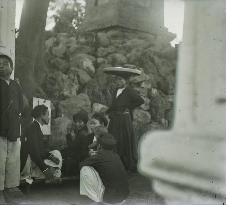 Các bà các cô tán chuyện với ông thầy bói cạnh tháp Bút, sau cổng Nghi Môn của đền Ngọc Sơn.