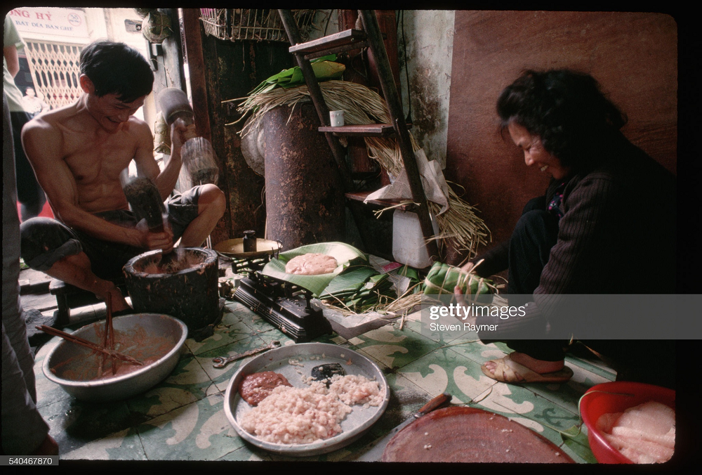 Tết xưa, các gia đình thường tự gói bánh chưng hay giã thịt làm giò chả. Ảnh: Steven Raymer.