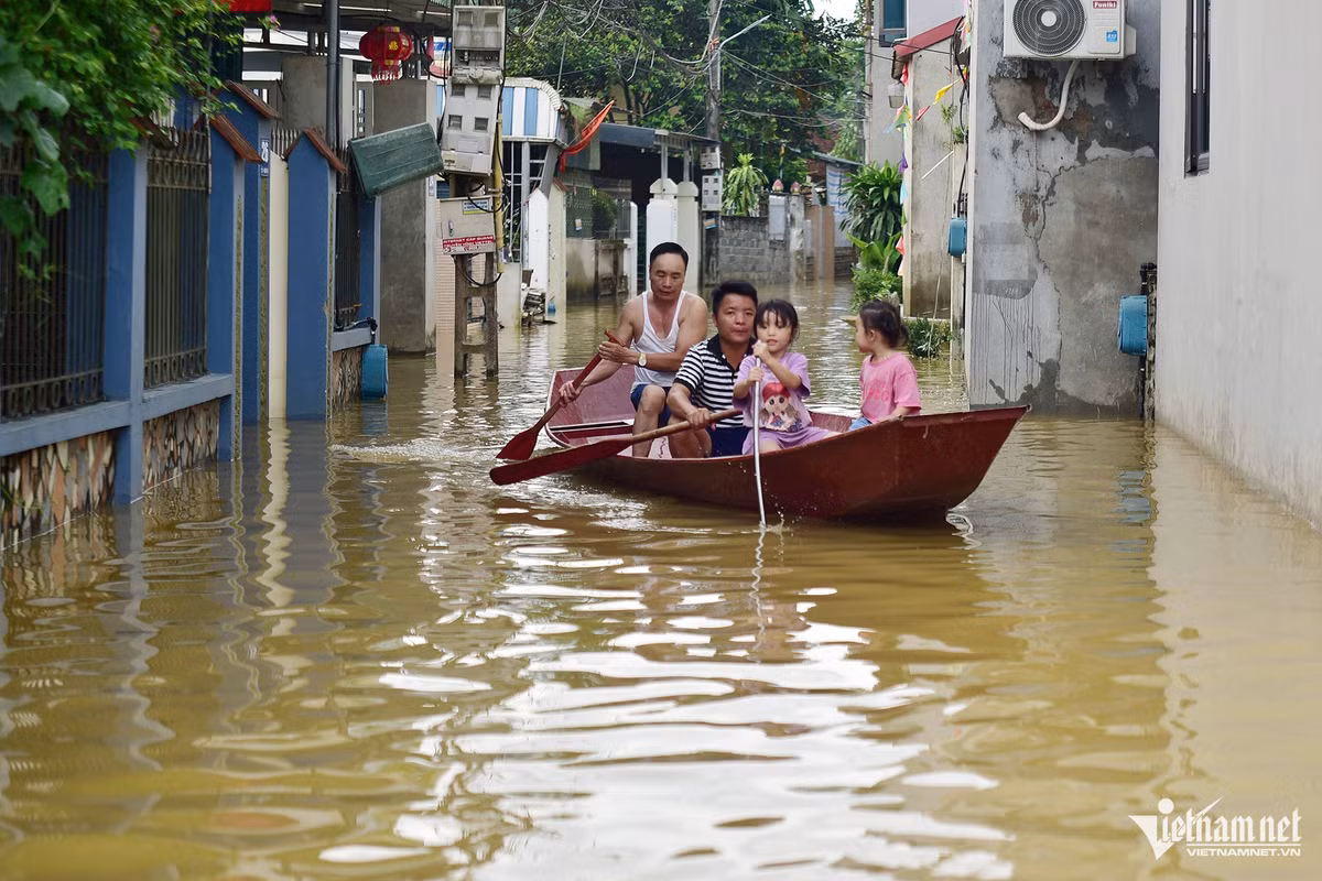 Người dân xã Tân Tiến mấy ngày nay phải đi lại bằng thuyền. Chiều 27/7, một số đoạn ngập nông nhất là khoảng 40cm. Ảnh: Đinh Tiến Cường