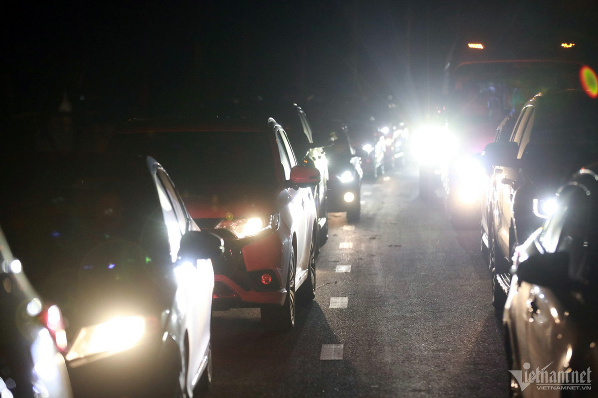 Ô tô sau khi ra khỏi bãi đi theo con đường có 2 làn xe khiến giao thông ùn ứ nhiều km. Sau 20h hàng dài phương tiện vẫn phải “bò” ra đường chờ soát vé.