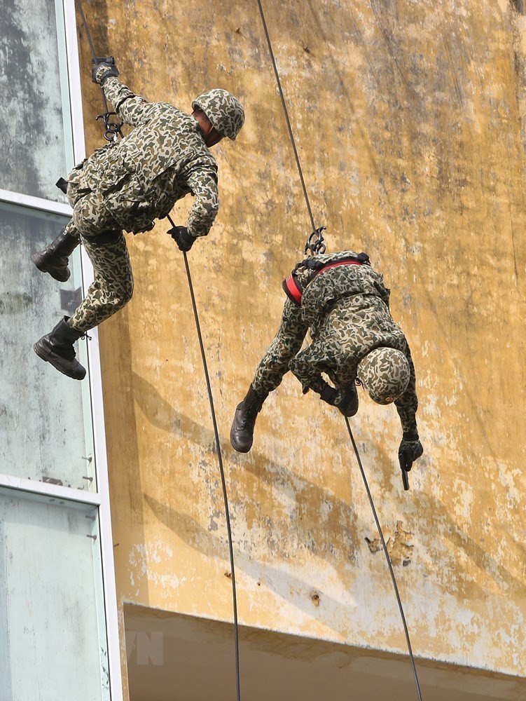 Bộ đội Đặc công trình diễn các kỹ thuật vừa tụt dây vừa tiêu diệt mục tiêu tại nhà cao tầng. (Ảnh: Dương Giang/TTXVN)
