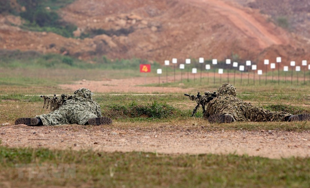 Bộ đội Đặc công trình diễn kỹ thuật ngụy trang và bắn súng. (Ảnh: Dương Giang/TTXVN)