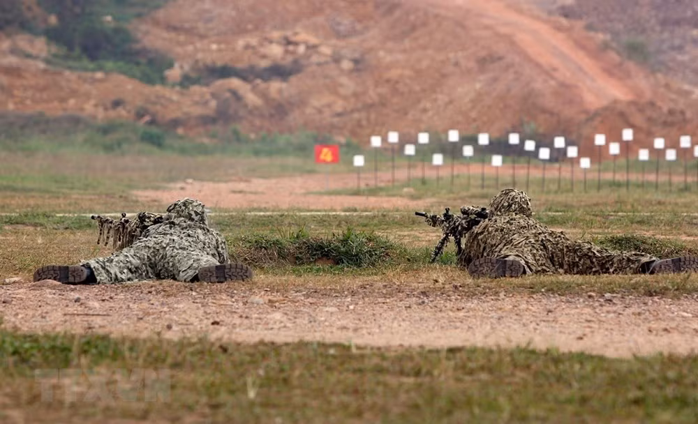 Bộ đội Đặc công trình diễn kỹ thuật ngụy trang và bắn súng. (Ảnh: Dương Giang/TTXVN)