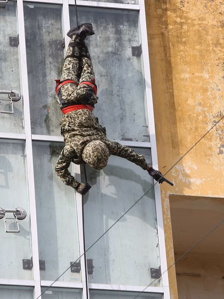 Bộ đội Đặc công trình diễn các kỹ thuật vừa tụt dây vừa tiêu diệt mục tiêu tại nhà cao tầng. (Ảnh: Dương Giang/TTXVN)