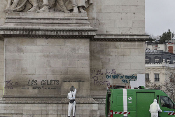 Những nhân viên vệ sinh dọn dẹp Khải Hoàn Môn chỉ để người biểu tình quay trở lại để vẽ tiếp lên đó những thông điệp của mình. Nguồn ảnh: TA.