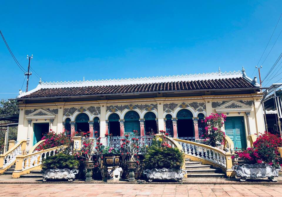 Bước qua rào cổng kiên cố bằng bê tông và sắt theo kiểu dinh thự Pháp, ngôi nhà cổ Bình Thủy nổi bật trên một khoảng sân rộng, được bao bọc bởi chùm hoa đủ màu, các chậu cây cảnh quanh năm xanh tốt làm không gian vừa có sẵn nét cổ kính, vừa sống động, tươi mới.