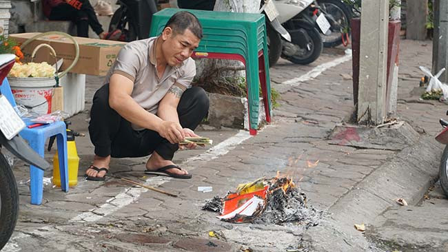 Người dân đốt vàng mã ở khu phố cổ Hà Nội sau khi cúng lễ ngày rằm tháng Giêng.