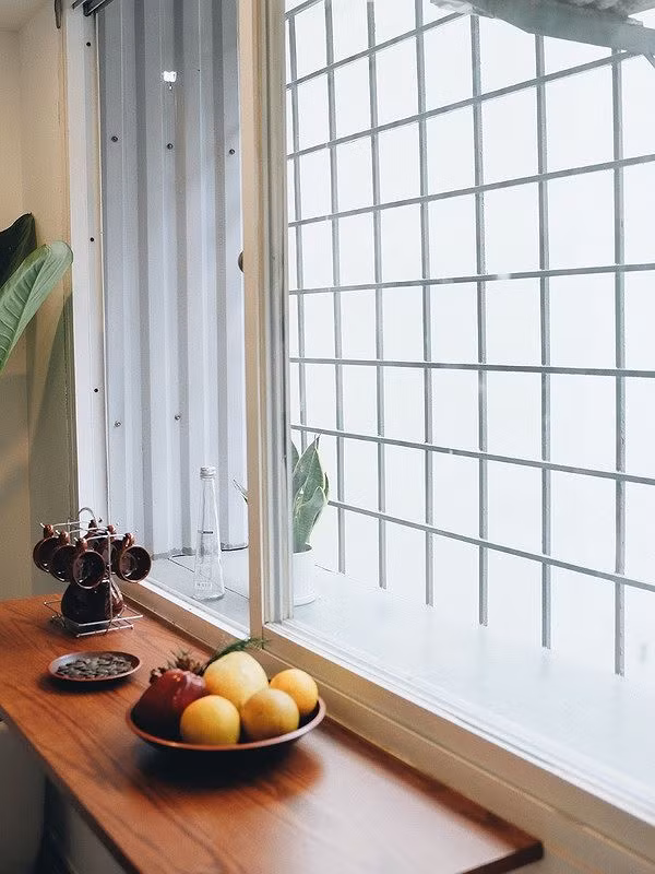 Một chiếc kệ gỗ được đóng thêm cạnh cửa sổ giúp gia chủ có thể thong thả uống trà, thưởng thức ăn ngắm khung cảnh bên ngoài.