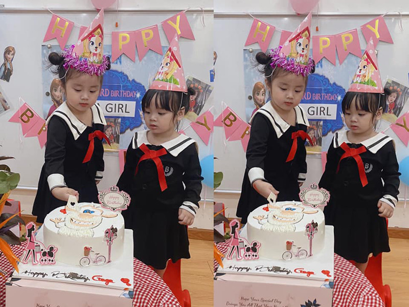 Bé Vy Lâm cắt bánh sinh nhật bên em gái Vy Lam.