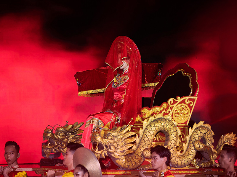 Nàng hoa hậu được khiêng đi dọc sân khấu, trên kiệu rồng chạm trổ tinh xảo.