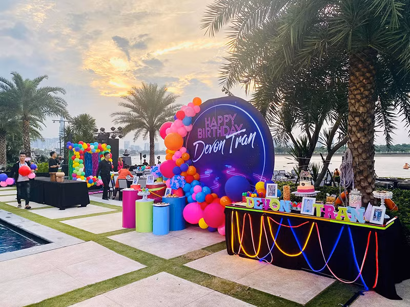 Tiệc sinh nhật của Bảo Tiên được tổ chức bên bể bơi, trang hoàng với bóng bay đầy màu sắc.