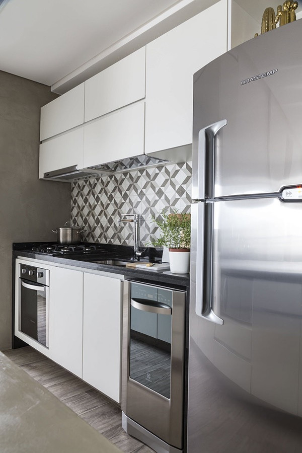 Khu vực bếp - ăn không lớn nhưng được xử lý rất khéo léo khi được ngăn cách bằng một bàn bar kiêm tủ bếp tiện dụng. Một lần nữa, hệ nội thất cao sát tường và được thiết kế riêng theo nhu cầu của gia chủ đã giúp cho khu nấu nướng dù rất nhỏ nhưng gọn gàng, tiện dụng.