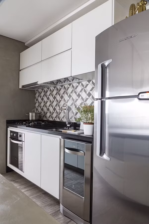 Khu vực bếp - ăn không lớn nhưng được xử lý rất khéo léo khi được ngăn cách bằng một bàn bar kiêm tủ bếp tiện dụng. Một lần nữa, hệ nội thất cao sát tường và được thiết kế riêng theo nhu cầu của gia chủ đã giúp cho khu nấu nướng dù rất nhỏ nhưng gọn gàng, tiện dụng.