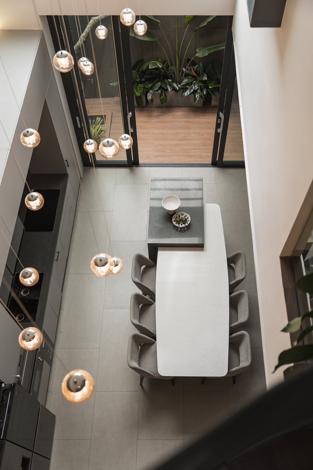 Hệ thống đèn chùm được đặt phía trên bàn ăn tạo ánh sáng huyền ảo, giúp bữa ăn thêm ngon miệng. 