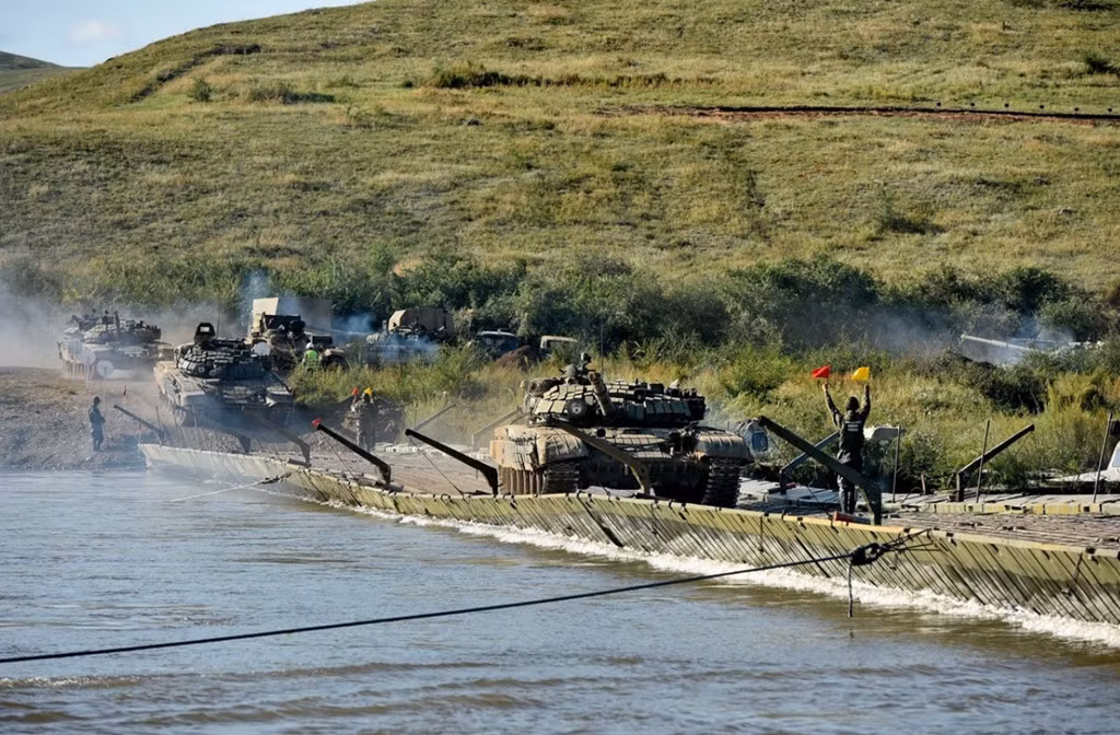 Xe tăng chiến đấu chủ lực T-72B3 lần lượt vượt sông bằng cầu phao. Do xe tăng có trọng lượng nặng nên chỉ có thể vượt sông từng chiếc một.