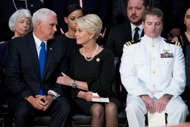 Phó tổng thống Mỹ Mike Pence, đại diện cho Tổng thống Trump, tham dự buổi lễ tại Điện Capitol. "Tổng thống đề nghị tôi có mặt tại đây, đại diện cho sự biết ơn của dân tộc, gửi sự tri ân và kính trọng tới người đàn ông đã dành cả cuộc đời phục vụ đất nước", Phó tổng thống Pence phát biểu tại buổi lễ. Trong ảnh, góa phụ Cindy McCain trò chuyện cùng Phó tổng thống Pence, bên cạnh là truy úy Jack McCain, con trai ông McCain. Ảnh: Reuters.