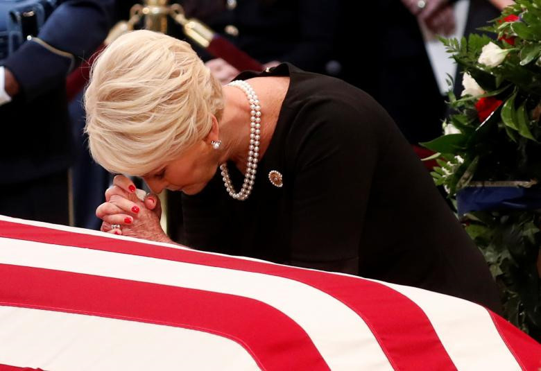 Bà Cindy McCain, phu nhân ông McCain, cầu nguyện bên thi hài, mở đầu buổi lễ. Sau bà Cindy, các thành viên khác của gia đình lần lượt tới cầu nguyện bên thi hài cố thượng nghị sĩ bang Arizona. Người cuối cùng là bà Roberta, mẹ của ông John McCain. Ảnh: Reuters.