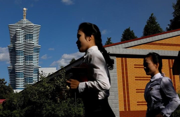 Người lao động Triều Tiên đi nhanh về phía cơ quan của mình bên trong một nhà máy tơ lụa.