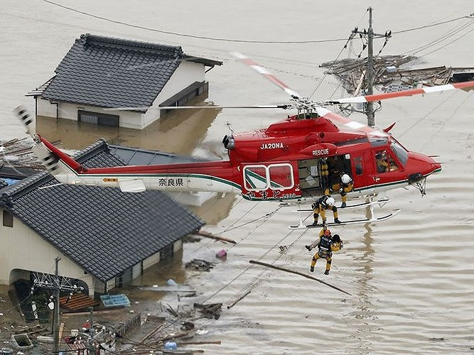 Lực lượng cứu hộ phải sử dụng cả trực thăng để sơ tán người dân vùng lũ. Ảnh: AP
