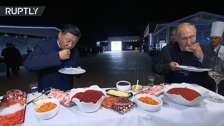 Theo Sputnik, khi bánh được rán xong, ông Tập Cận Bình muốn dùng dĩa để ăn nhưng Tổng thống Putin nói rằng hãy cầm tay ăn theo cách ăn truyền thống của người Nga.