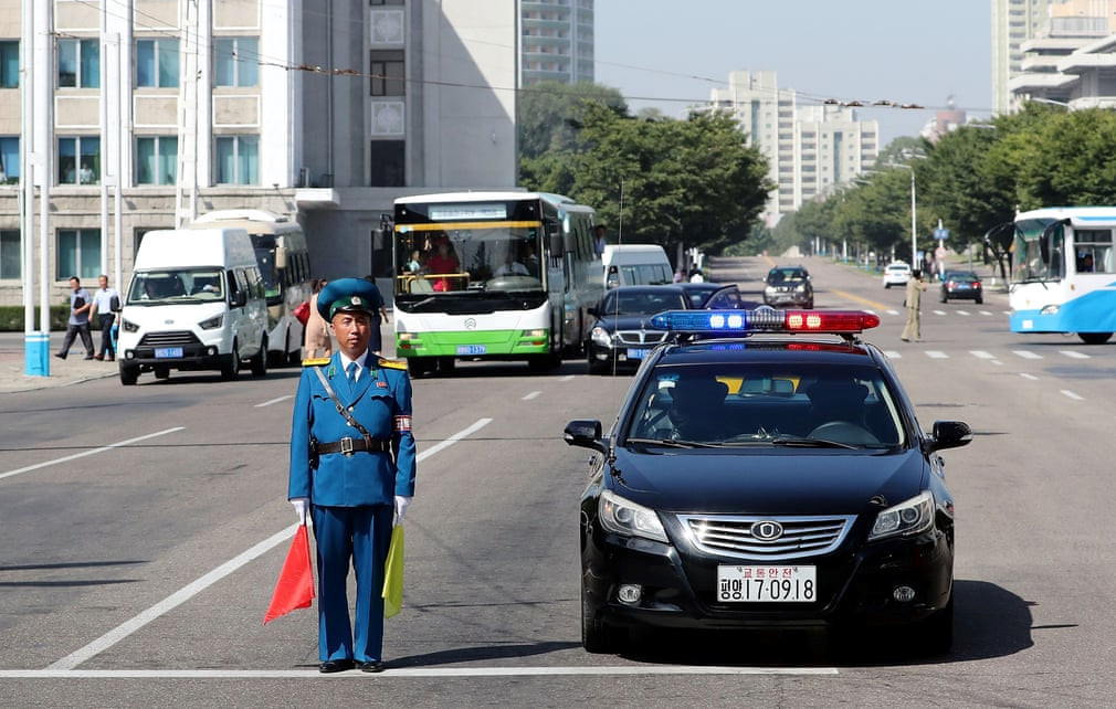 Chính quyền Bình Nhưỡng siết chặt an ninh tại thủ đô trong suốt 3 ngày ông Moon viếng thăm. Truyền thông quốc tế cho biết đường xá thành phố những ngày này không quá đông đúc và vô cùng sạch sẽ. Trong ảnh là một chốt cảnh sát giao thông Triều Tiên diều phối mở đường cho đoàn xe của ông Moon Jae In ngày 18/9. Ảnh: Getty.
