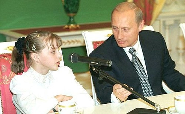 Ông Putin chỉnh micro giúp cô bé Anna Pavlova trong chương trình Thần đồng nhí nước Nga năm 2002. Ảnh: Kremlin