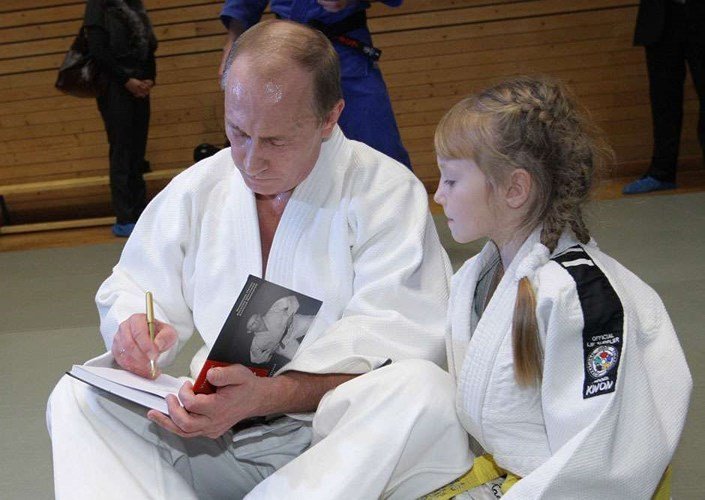 Hình ảnh vừa giản dị vừa ấm áp khi ông Putin mặc võ phục Judo ngồi ký tặng sách cho một cô bé. Ảnh: AP