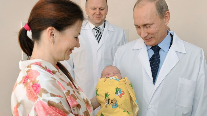Ông Putin mỉm cười với một em bé sơ sinh khi thăm Kaliningrad ngày 2/11/2011. Ảnh: AFP