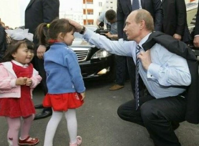 Tổng thống Putin ân cần trò chuyện với một cô bé. Ảnh: Pinterest