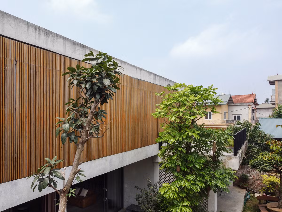 Mặt trước của căn nhà ấn tượng với hệ thống cửa nan tre ép khung sắt có thể đóng mở linh hoạt.