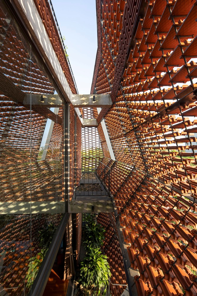 Giữa lớp áo bên ngoài và các phòng chức năng là ban công nhiều cây xanh, đóng vai trò như lớp không gian chuyển tiếp, giúp điều hòa khí hậu. Ảnh: Lê Minh Hoàng