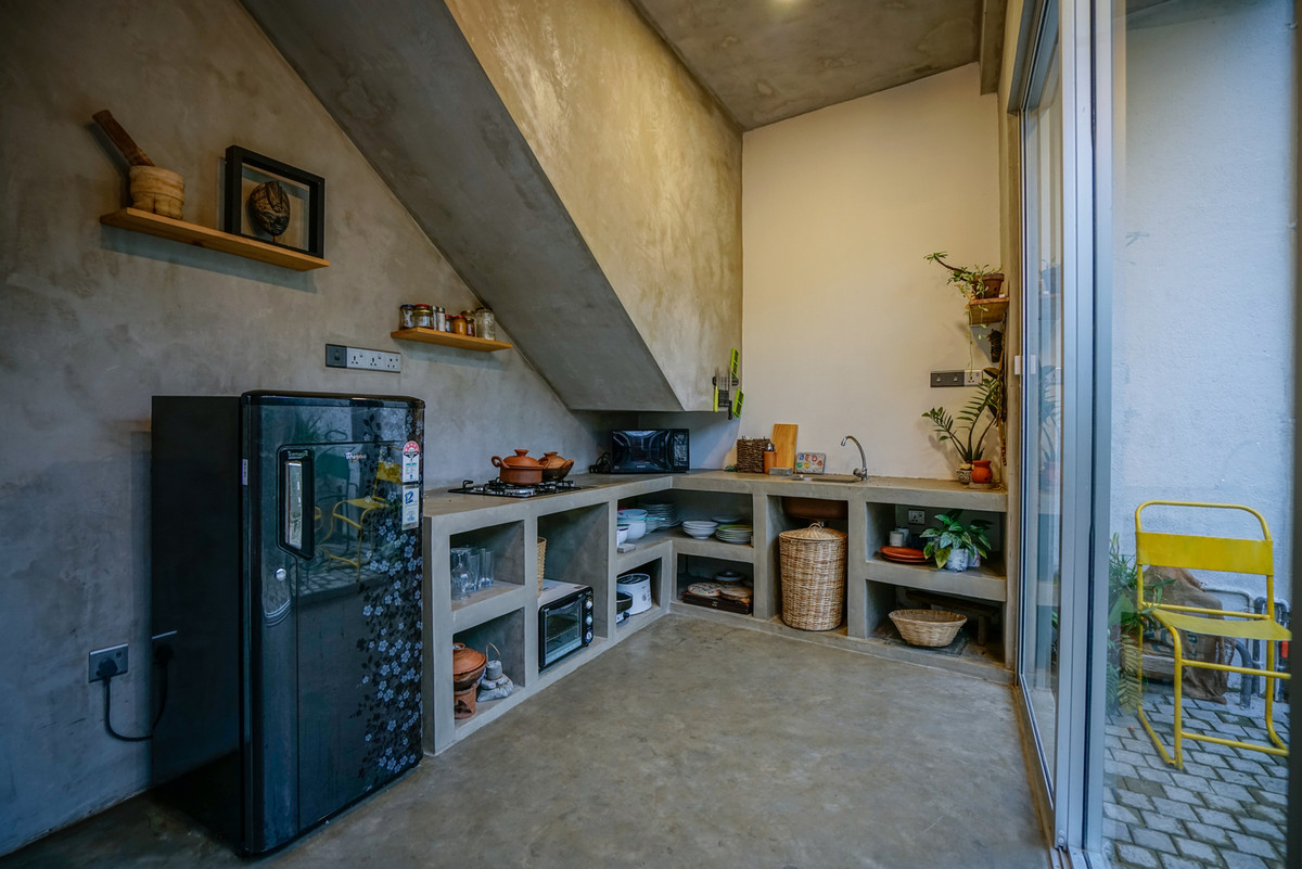 Phòng bếp đơn giản, tiết kiệm với toàn bộ phần sàn, tường và mái nhà được để thô không sơn. Ảnh: Archdaily