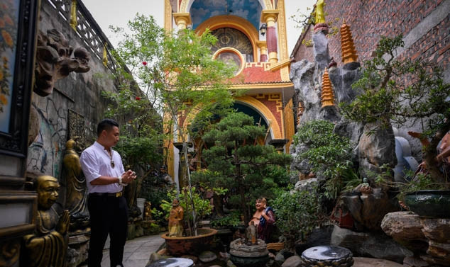 Trong sân của ngôi nhà kỳ quái có một hồ nước róc rách, trên đó dựng thành một quả núi nặng 20 tấn từ 5 loại đá, sỏi lấy ở 5 vùng khác nhau, thả 100 con cá chép vàng bơi xung quanh và trồng nhiều cây cối để tạo phong thủy cho ngôi nhà. Ảnh: Dân Việt