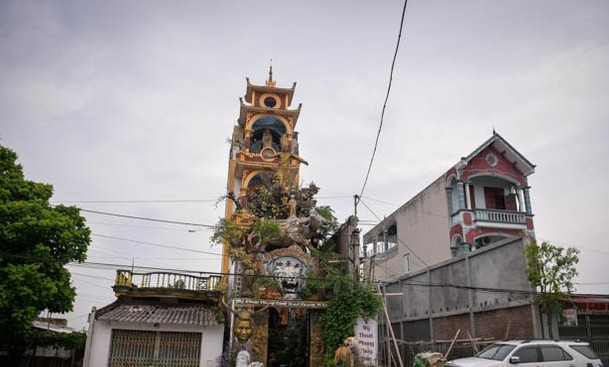 Ngôi nhà gồm 4 tầng, xây kiểu nhà ống bình thường. Tuy nhiên, phần mặt tiền được thiết kế cong vút như mái chùa. Ảnh: Dân Việt