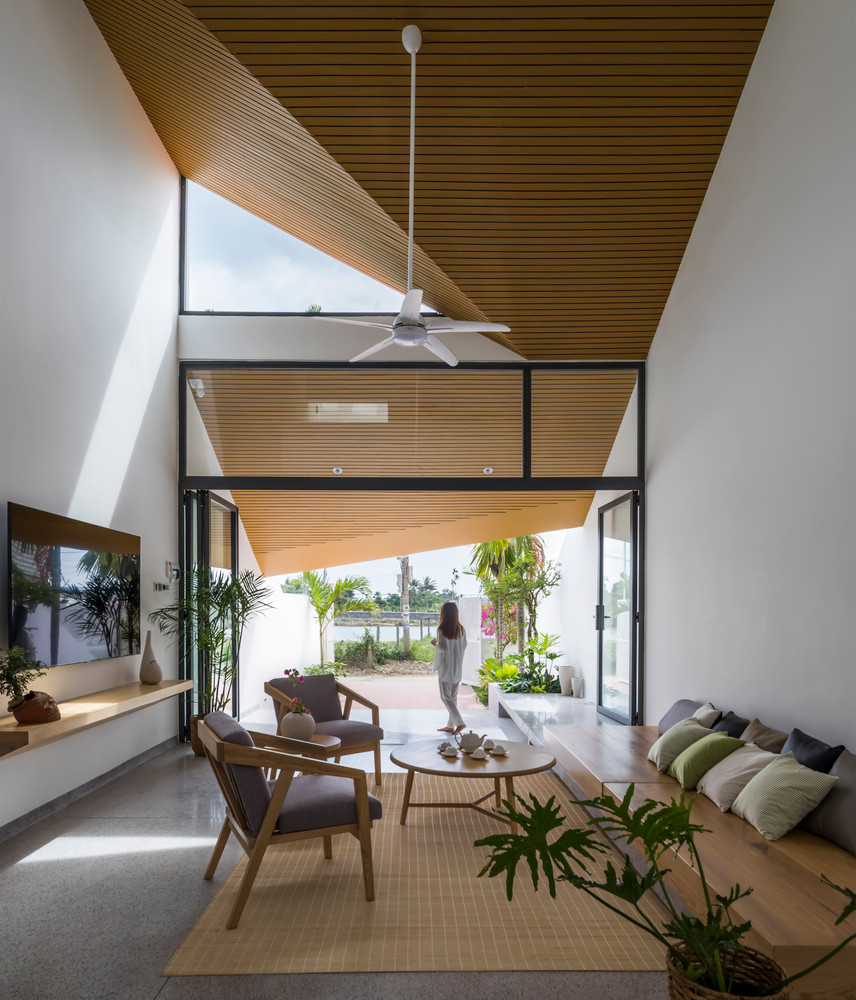 Không gian bắt đầu đóng dần khi giảm cao độ trần tại khu vực phòng ăn và đóng hẹp lại khi qua hành lang kết nối ra phía sau nhà.