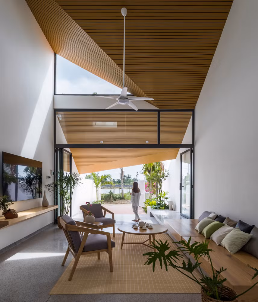 Không gian bắt đầu đóng dần khi giảm cao độ trần tại khu vực phòng ăn và đóng hẹp lại khi qua hành lang kết nối ra phía sau nhà.