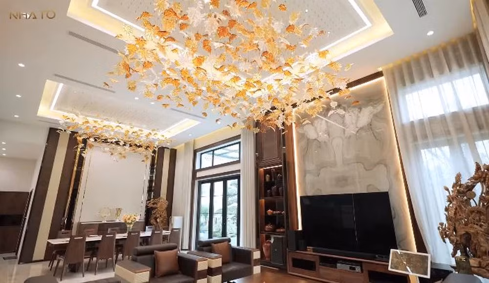 Kết quả, tầng 1 là không gian phòng khách và bếp rộng rãi, thoáng đãng, được bố trí nhiều đồ gỗ óc chó Mỹ, đèn treo.