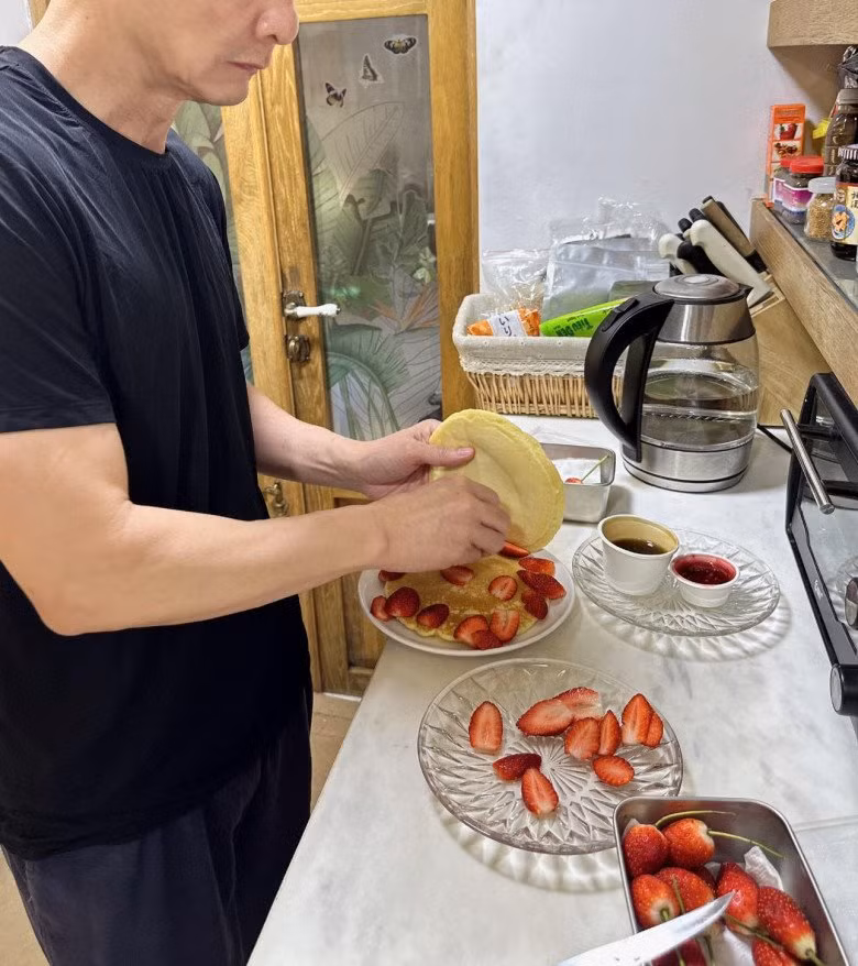 Vừa qua, Phan Như Thảo chia sẻ chia sẻ hình ảnh đại gia Đức An bận rộn làm bánh pancake dâu tây cho bé Bồ Câu. Ảnh: FBNV