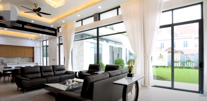 Hai mặt của phòng khách đều bằng kính giúp gia chủ thoải mái ngắm cảnh sân vườn.