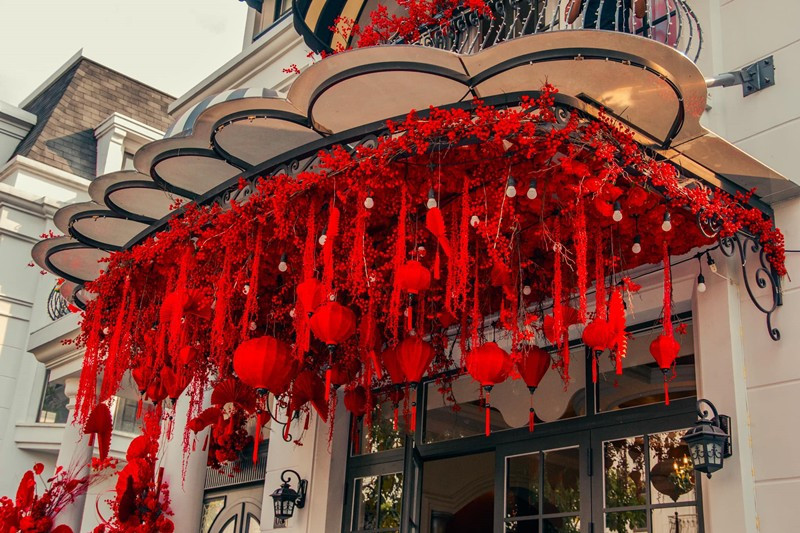 Những chiếc đèn lồng, cành đào đông, quạt giấy đỏ treo trên mái hiên giúp không khí Tết thêm rộn ràng.