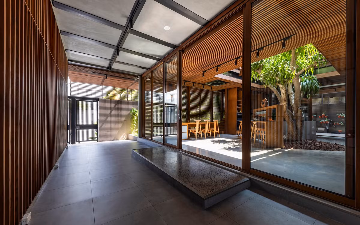 Nhằm đáp ứng nhu cầu của gia chủ, kiến trúc sư triển khai giải pháp thông minh mang tên “Mặt tiền hai lớp”. Cấu trúc này bao gồm hệ thống lam gỗ nhiệt (gỗ đã được xử lý nhiệt để tăng độ bền) ở bên ngoài, kết hợp với hệ thống kính trượt bên trong.