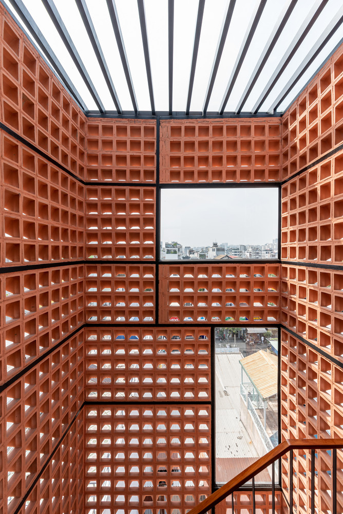 Mặt sau của cầu thang ốp gạch bông gió, loại ngói phổ biến ở địa phương, tạo sự thông thoáng đối lưu nhưng không bị mưa tạt, đồng thời kết hợp các tấm kính để lấy sáng tạo cửa sổ nhìn lên trời. Ảnh: Lonton Studio