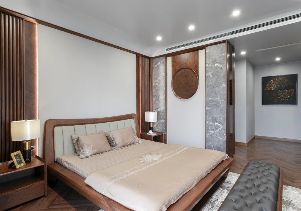 Phòng ngủ chính thiết kế hiện đại, sử dụng gỗ óc chó làm điểm nhấn. Ảnh: Dân trí
