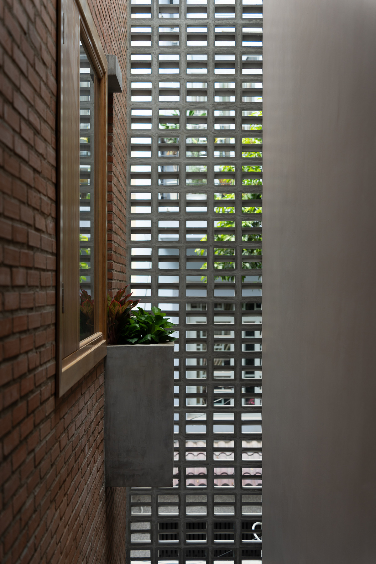 Kiến trúc sư định hình không gian bằng một mảng tường gạch chạy suốt từ trệt lên đến mái. Ảnh: Quang Dam/G+architects