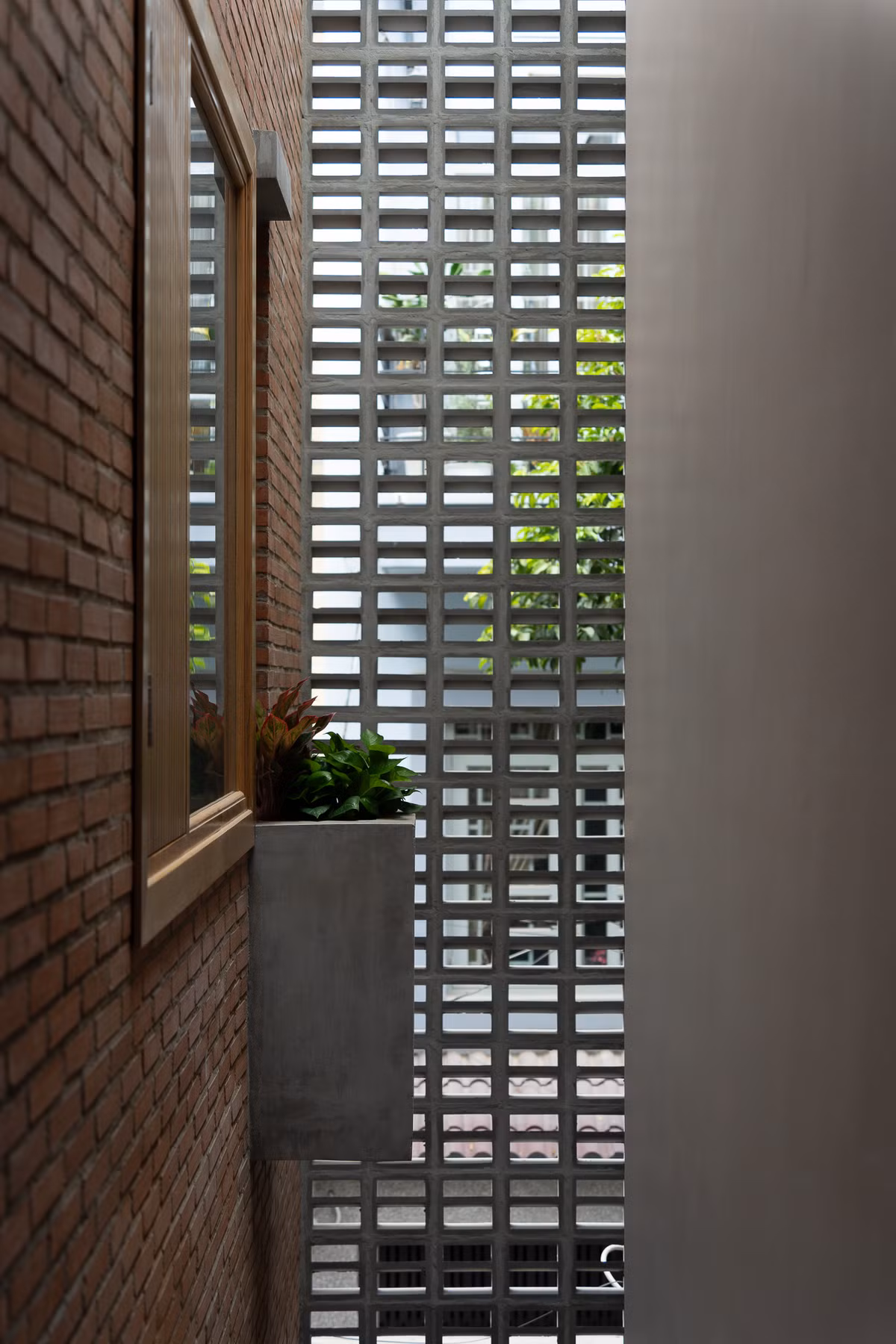 Kiến trúc sư định hình không gian bằng một mảng tường gạch chạy suốt từ trệt lên đến mái. Ảnh: Quang Dam/G+architects