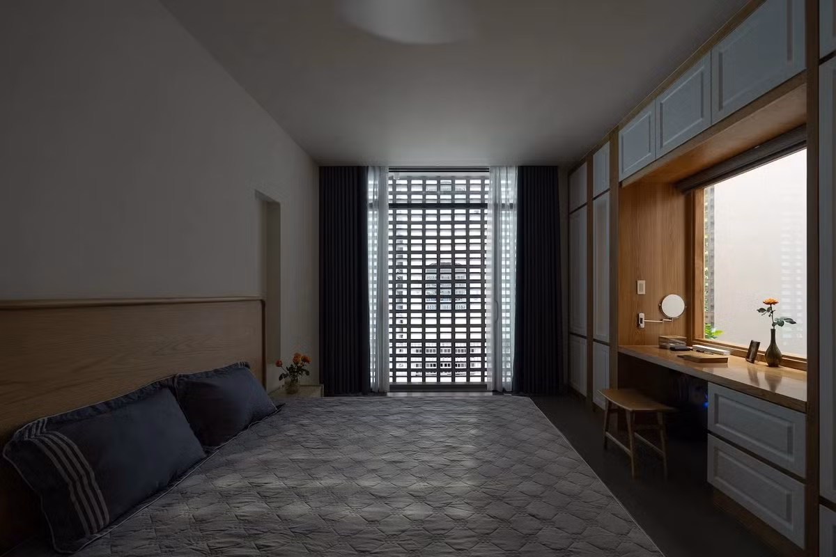 Phòng ngủ lấy sáng từ 2 mặt, cửa kính khiến bàn làm việc luôn đủ ánh sáng tự nhiên mà không cần hệ thống đèn cầu kỳ. Ảnh: Quang Dam/G+architects